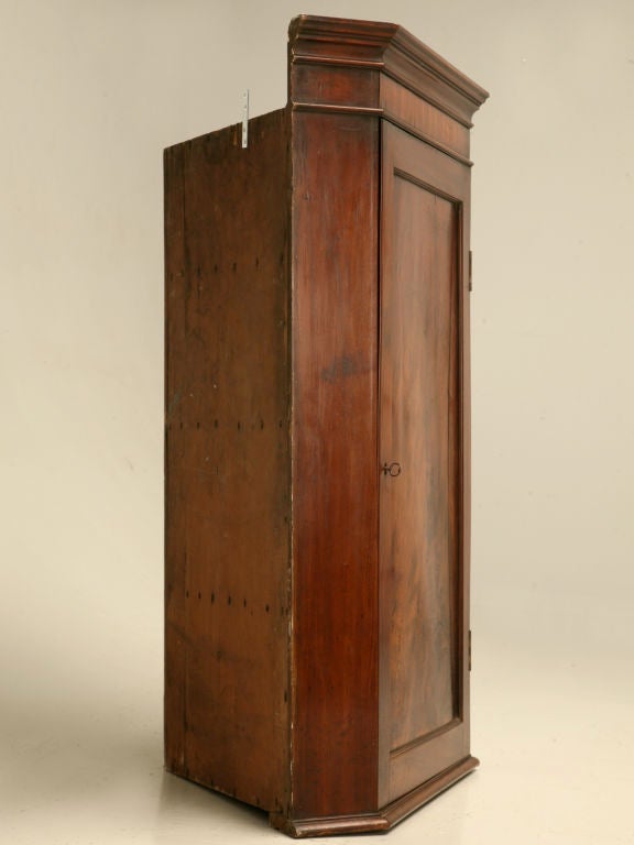 Remarkable antique English crotch mahogany hanging corner cupboard. This beauty is a must have for those of you needing storage, but haven't a square inch of floor space to offer. Ingeniously designed to add substantial storage by hanging up off the