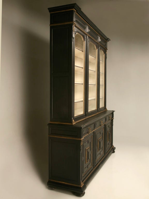 Breathtaking antique French Napoleon III breakfront bibliotheque or china cabinet. It draws the eye with it's dramatic black finish, it's subtle gold trim highlights, and it's winter white interior. Amazing utilized in most any room, be it the