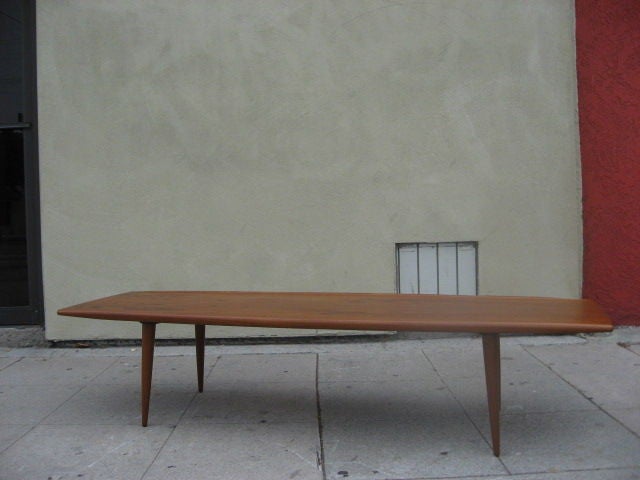 Simple design teak coffee table, top slightly wider in middle.