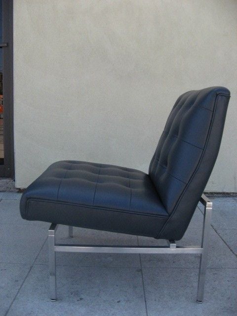 A Parallel bars style slipper chair in the manner of Florence Knoll with dark blue tufted leather upholstery and chromed aluminum frame.
