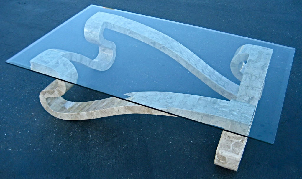 Énorme table basse sculpturale plaquée de carreaux de pierre fossile polie.  Plateau en verre épais biseauté.