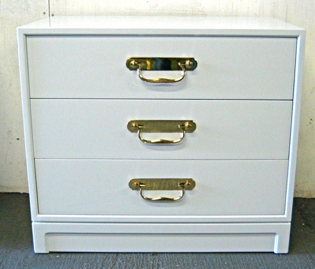 Bedside Chest of Drawers in White Lacquer with Polished Brass bale pulls attributed to Dorothy Draper for Henredon.  The piece has been freshly refinished and the hardware has been professionally polished and clear-coated.