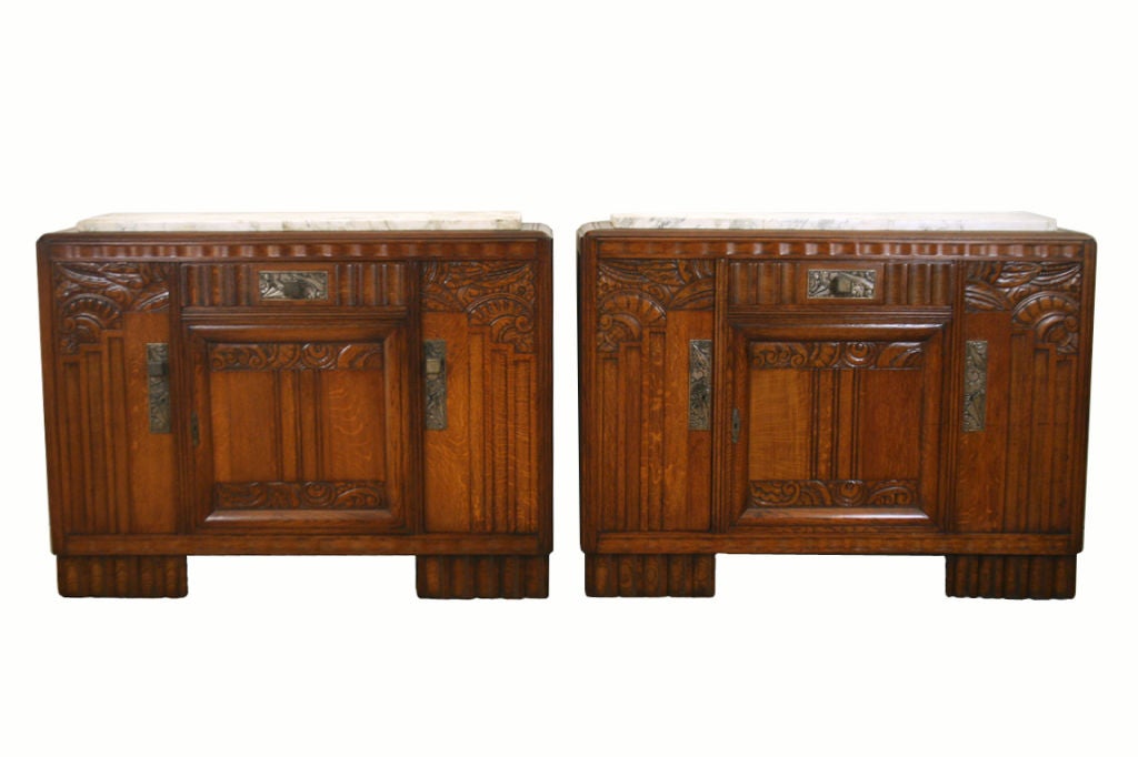 well carved pair of one drawer and three door oak credenzas having fluted column feet and nickel hardware, having white with black accents marble tops, with working locks.  measurement of depth is 19.5 inches to hardware and 17.75 to body

Please