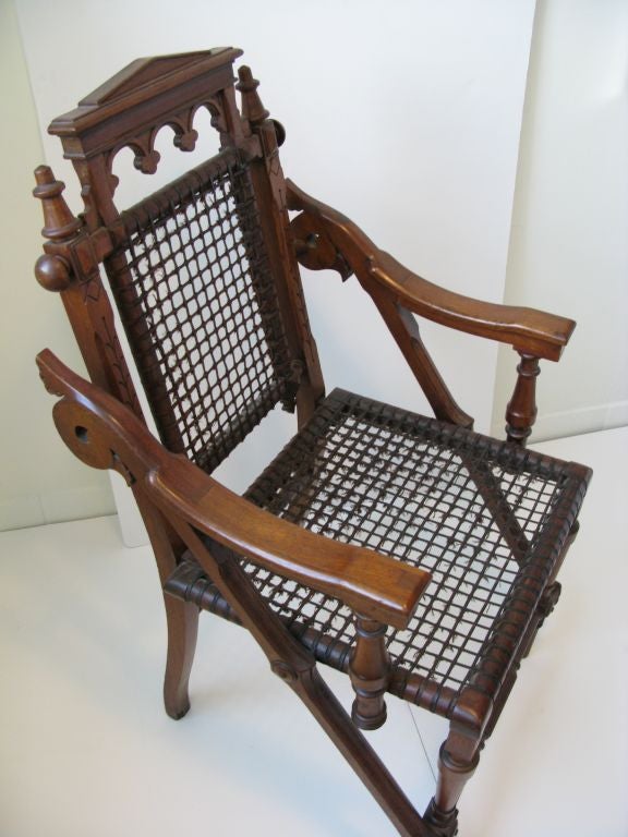 Superb Aesthetic armchair by innovative furniture designer George Hunzinger. Artfully balanced and restrained Renaissance and Moorish revival elements, given architectural bearing by patented wire mesh seat and back. The only example of this design