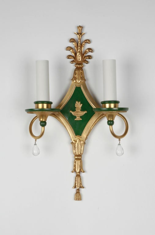 AIS2625

A pair of antique Caldwell sconces with their original gilded copper and green painted finish. The diamond-shaped backplate frames a low relief image of a brazier. The scrolling arms are dressed with teardrop crystals and rise to support