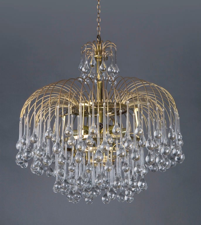 HL3472<br />
An antique nine-light chandelier dressed with crystal drops descending from brass sprays. Shown here in its original finish. Due to the antique nature of this fixture there may be nicks or imperfections in the glass.<br />
<br