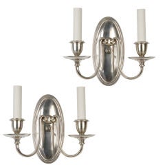 A pair of two arm silver sconces
