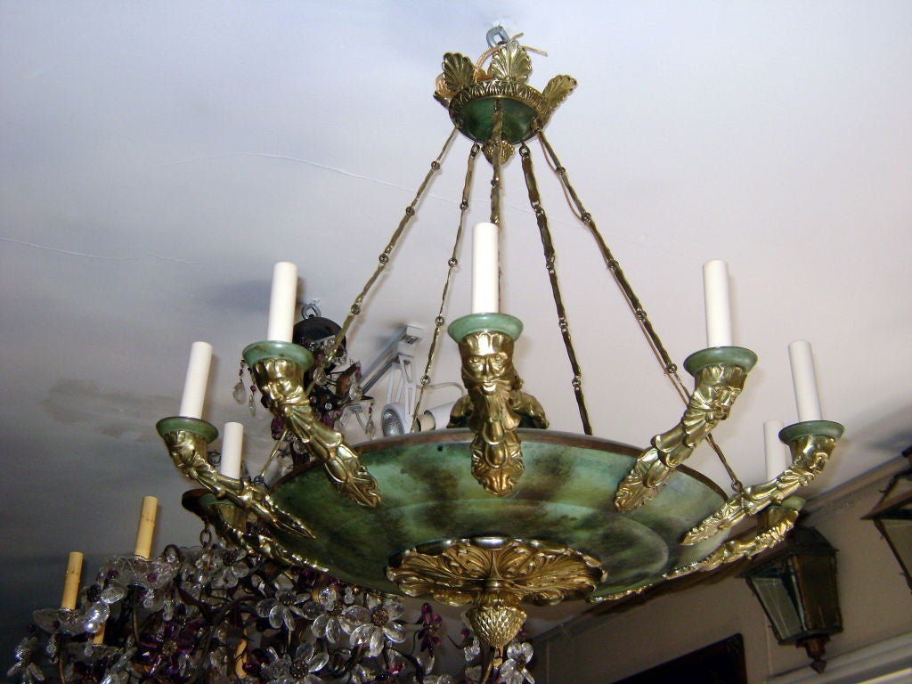 A large circa 1920's French Empire style chandelier with face details on arms and verdigris painted finish.

Measurements:
Height (minimum drop): 32