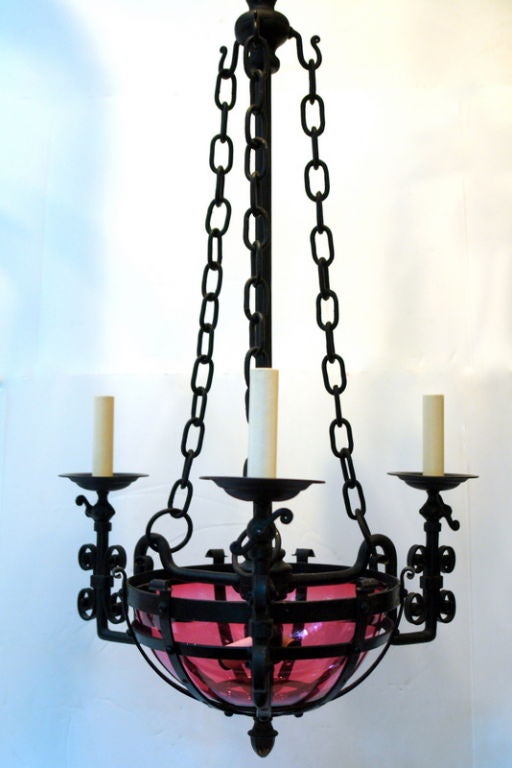 A late 19th century American wrought iron chandelier converted from gas with original cranberry glass bowl.

Measurements:
Height: 40