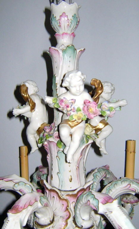 A circa 1960's porcelain six-light chandelier with floral details and with putti on body. Gilt details. Porcelain manufactory brand marked Rudolf Kämmer, Rudolstadt-Volkstedt.  

Measurements:
Height: 25.5