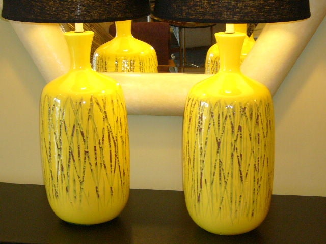 SOLD NOV.2009     Terrific pair of yellow glazed ceramic lamps with incised decoration of a bamboo thicket or jackstraws.  Incised design in matte glaze plum color.  Great size and scale.  In Wearstler yellow.... sunny, bright and unforgettable. 