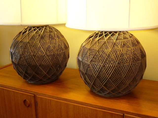 Unique woven cane orb lamps with a wonderful optic in the weave.  Smart & handsome with great scale...original cocoa brown stain.  Recalling Buckminster Fuller's geodesic domes, they are uniquely beautiful.  Just add your shades.<br />
<br