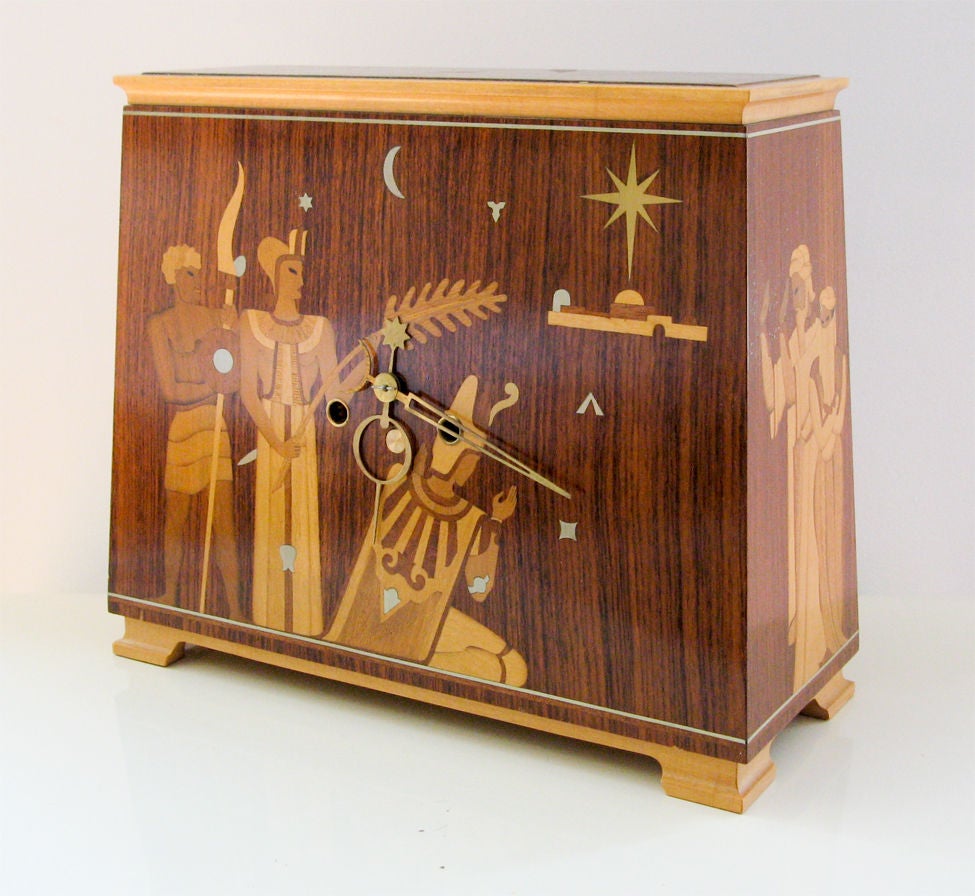 Delightful figural wood and pewter marquetry Art Deco mantel clock made in Sweden and designed by Anders Lindner for Mjolby Intarsia. Mjolby Intarsia was renowned for its brilliant marquetry craftsmanship. The firm also provided work for NK in