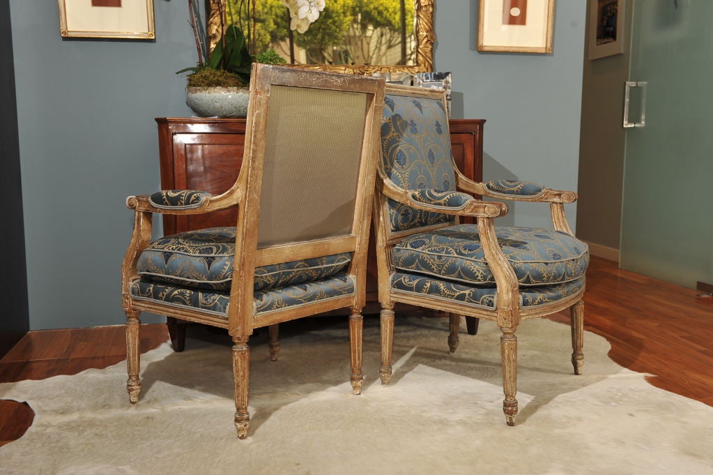 Handsome pair of wood framed upholstered armchairs.  Frames are in original condition, with gorgeous patina on paint. Chairs have been newly upholstered in smoky periwinkle and slate blue fabric with coordianting strie fabric on the back.