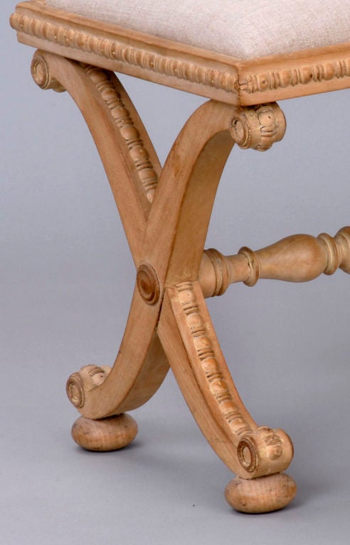 William IV sycamore stool with carved X-shaped and scrolled legs, baluster turned stretcher, carved beading around frieze and down sides of frame, supported on bun feet. Drop-in seat upholstered in beige linen.