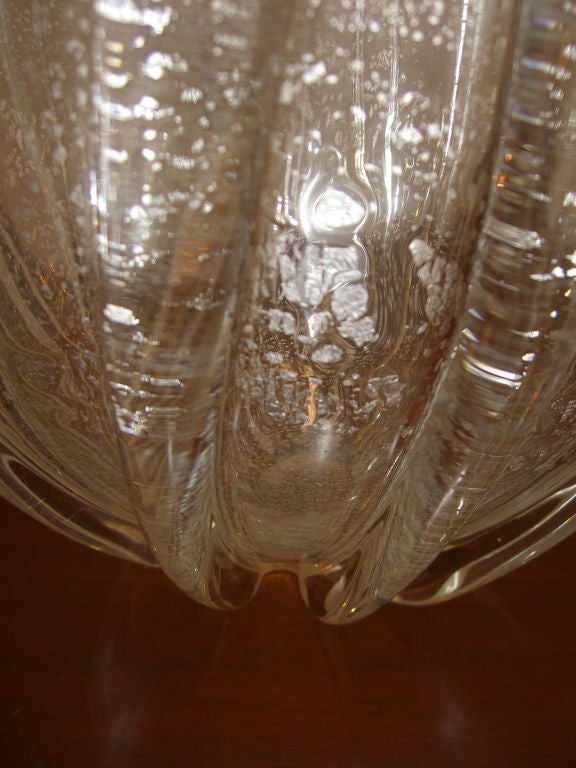 A nice clear heavy glass ribbed vase white white flecks produced by Mikasa in the 1970's. In an coincidental happenstance the designer of this vase identified for us at a trade show and explained that he designed it for Mikasa in the 1970's. I can't