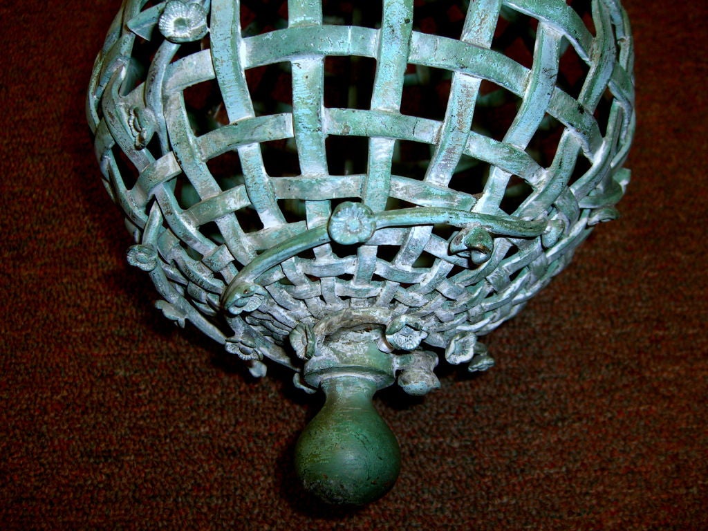 A quite unusual and whimsical bird cage or most likely a hanging feeder, in the shape of a ball cage. It is made of bronze and features a wonderful blue green patina, except for parts of the holding ring. The way the door opens implies a bird or