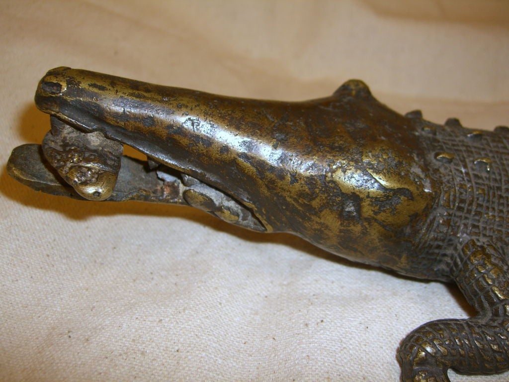 A great African bronze of a Crocodile with it's prey in it's mouth. I'm not sure which region this is from, but it is well executed and detailed with a nice rich patina. There is a squiggle mark to the underside of the snout, pictured, which may