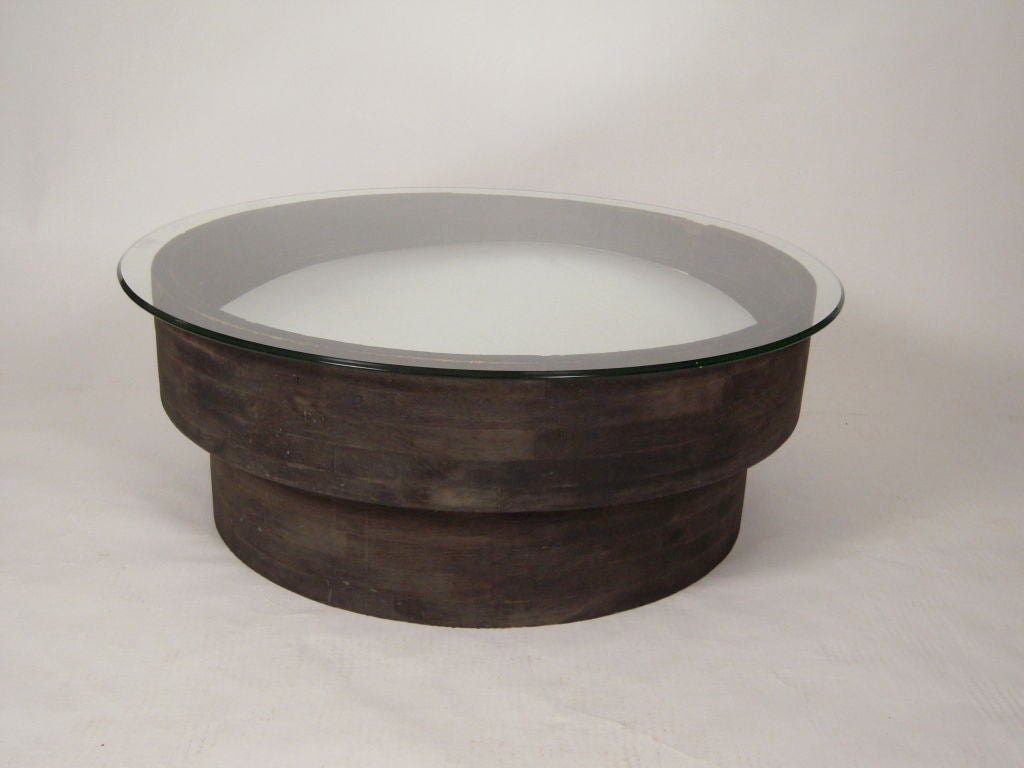 An unusual round coffee table made from an antique industrial round wood foundry mold (used to make casts of metal industrial machinery parts)  with a modern convex, non-breakable round mirror inserted in the center surmounted by a 42