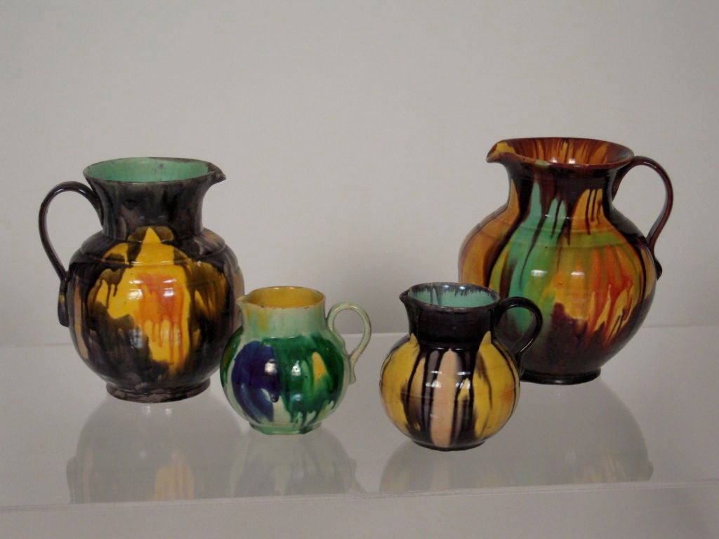 A hard-to-find collection of 4 vintage Mexican (from Oaxaca) drip glazed pottery pitchers in various colors with green and yellow interiors, acquired from a private Texas collection which was built over many years. These wares are hard to find and