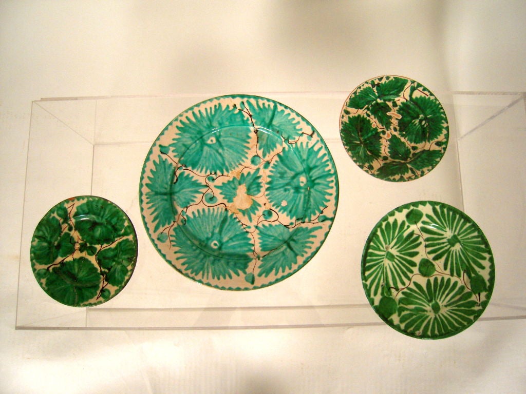 A collection of striking, vintage hand painted green and white pottery plates depicting flowers and vines, from Oaxaca in southernmost Mexico, acquired from a private Texas collection which was built over many years. These wares are hard to find and
