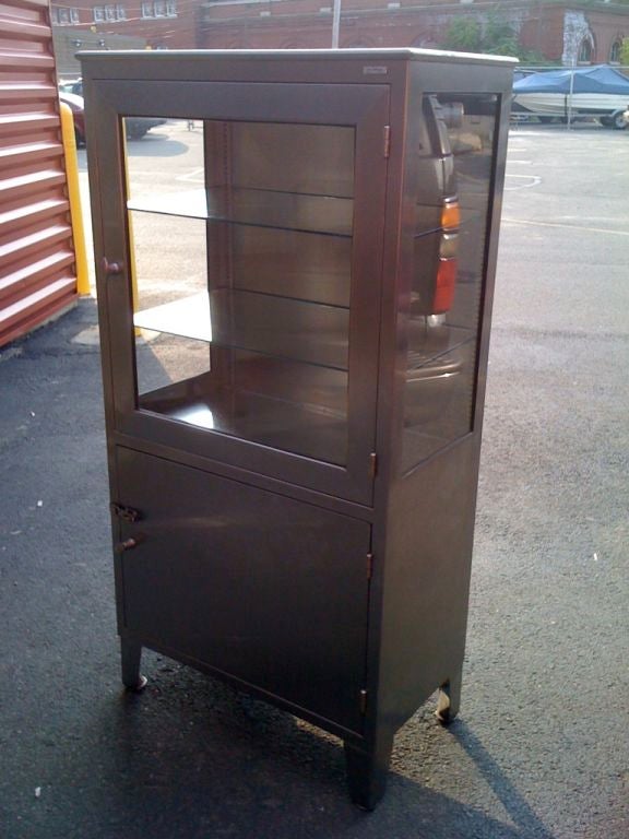 Two door stainless steel medical cabinet with adjustable glass shelves.