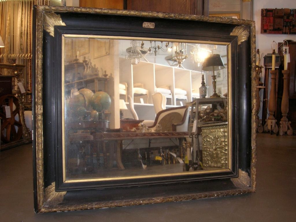 Large 19th century ebonized and gilded rectangular mirror with gilded leaf detailing. New mirror. Mirror sight: 45