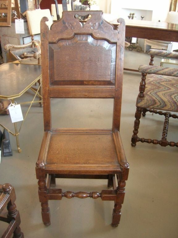 Set of four 19th century Jacobean side chairs with inlaid scroll and dolphin detailing. 

Measures: Three chairs: 43.75 H x 14.5 D x 17.5 W. 
One chair: 41 H x 14.5 D x 17 W.