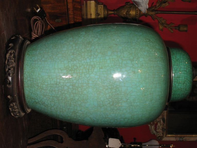 ovoid shape, brass edged cover lid, carved wooden base with floral motif, crackle glaze