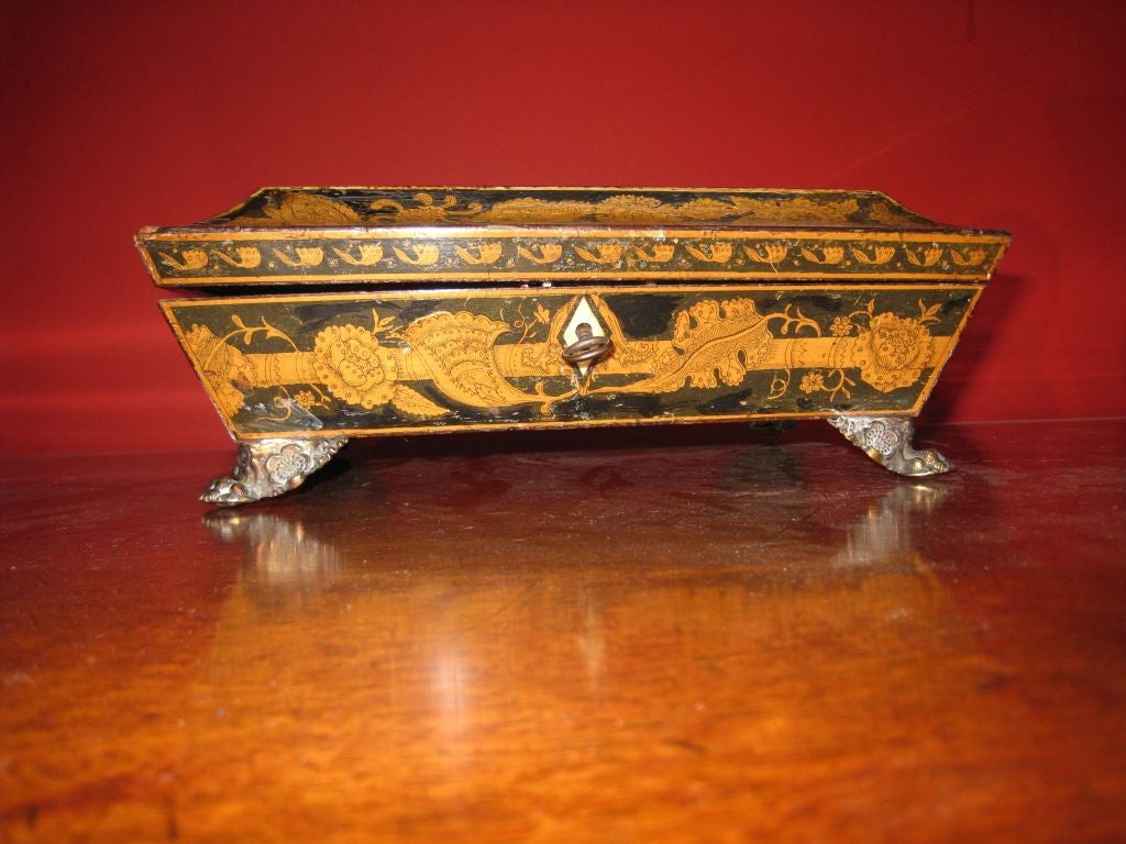 penwork box with central mythological scene and scrolling leaf pattern, brass claw feet, counters and chips inside