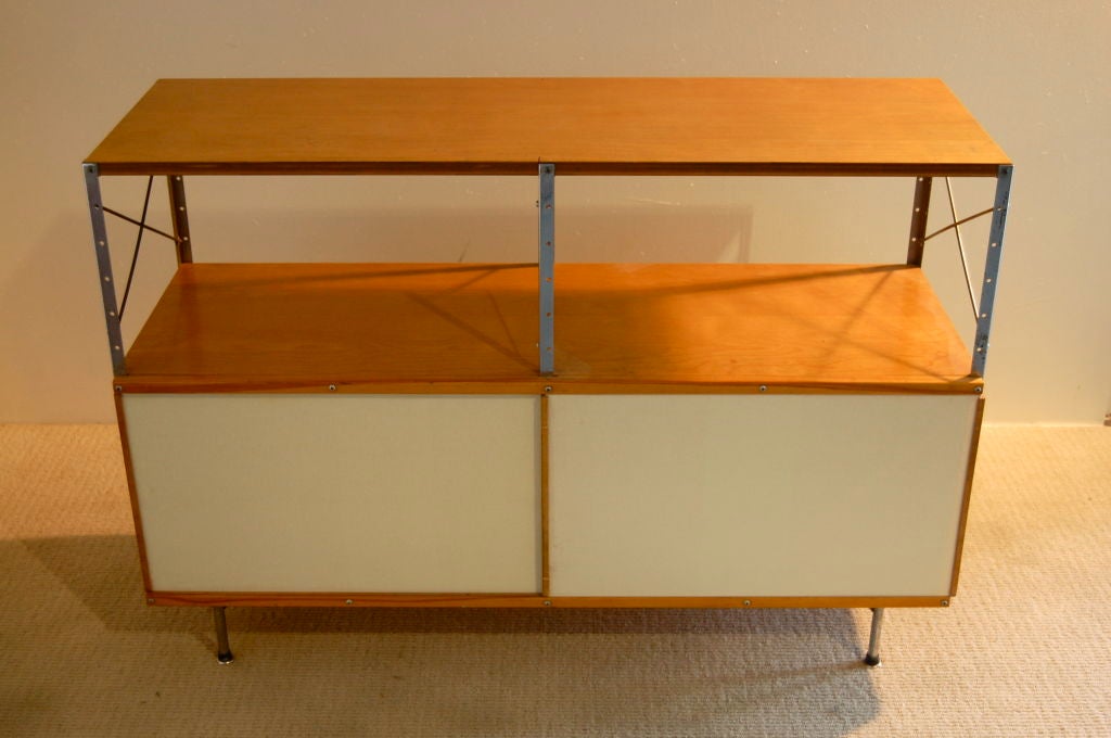 Charles Eames for Herman Miller ; Second series ESU (Eames Storage Unit) model 230-N , Birch top with upper shelf completely open , lower section enclosed by neutral panels and sliding white masonite doors . The 1952 Herman Miller catalogue shows