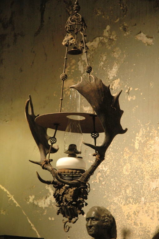 Museum quality handmade wrought iron and horn chandelier exhibited at the 1893 Columbia Exposition in Chicago.
Manufactured in 1892 by Reinhold Kirsh in Munich Germany. Exceptional metal work with extremely fine details. Glass kerosene lamp and