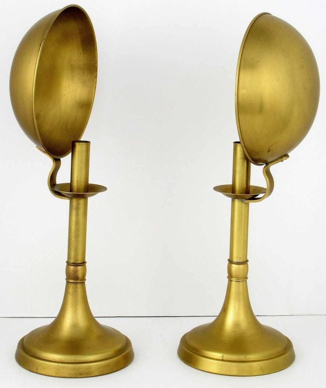 Unusual and rare offering from Sarreid. These two candlesticks, with large concave reflectors, are constructed of solid brass. The original patina has been left untouched, but could be polished if so desired.