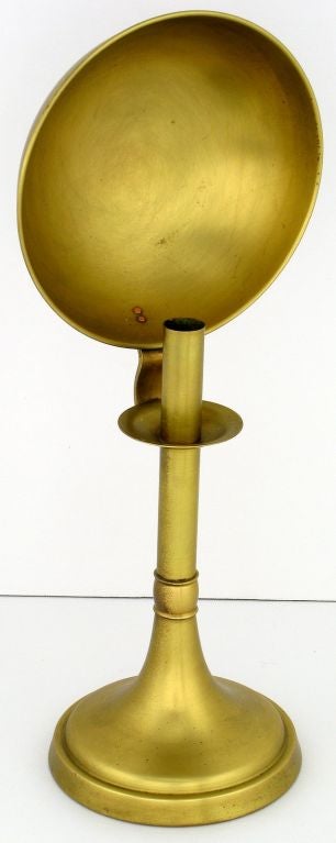 a candlestick holder has a concave reflector