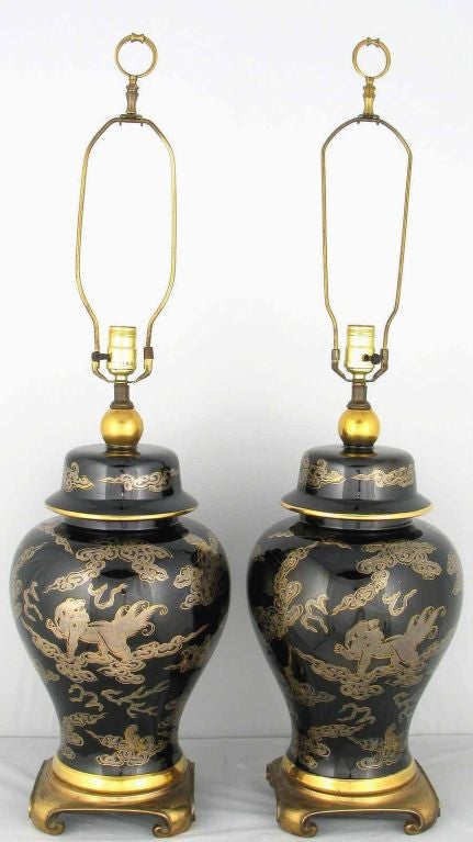 Elegant black and gilt Asian ginger jar form table lamps with solid brass turned feet bases. Sold sans shades.