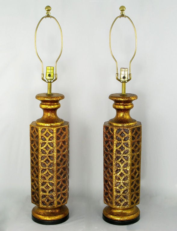 Striking pair of table lamps with eight-sided Moorish arabesque reliefs, octagonal gilt ceramic bodies and impressive size. Sold sans shades.