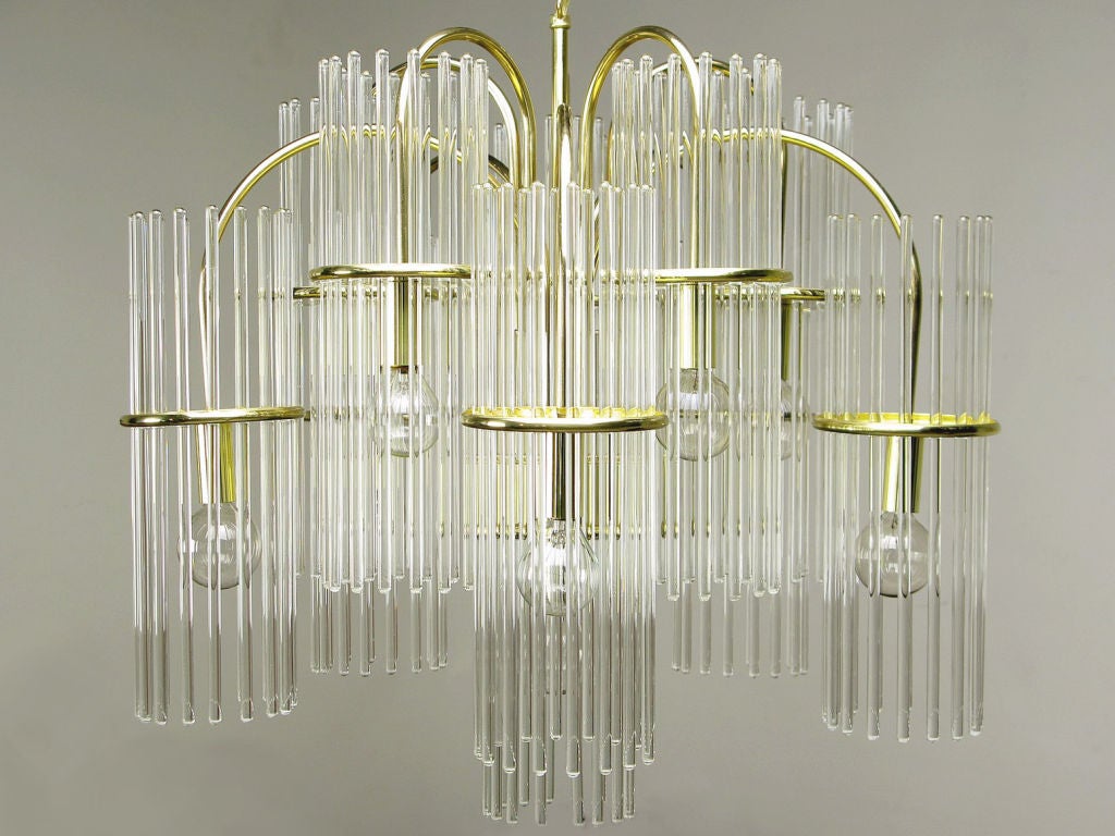 Striking glass rod and brass chandelier from lighting giant Lightolier, evoking the pendulous branches of a weeping willow. Each of the eleven arms arcs upward, then down.  The glass rod crystals come together to resemble a lighted fountain.