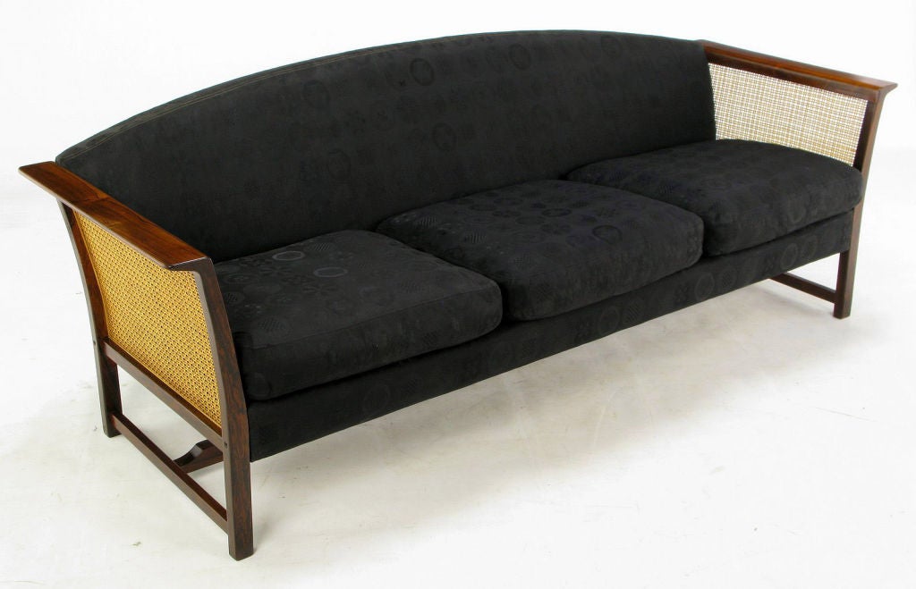Clean lined modern sofa with a Brazilian rosewood frame, caned sides, and geometric patterned black silk blend damask upholstery. Rosewood frame with side and center stretchers is wonderfully grained, and retains the deep reds and browns that make