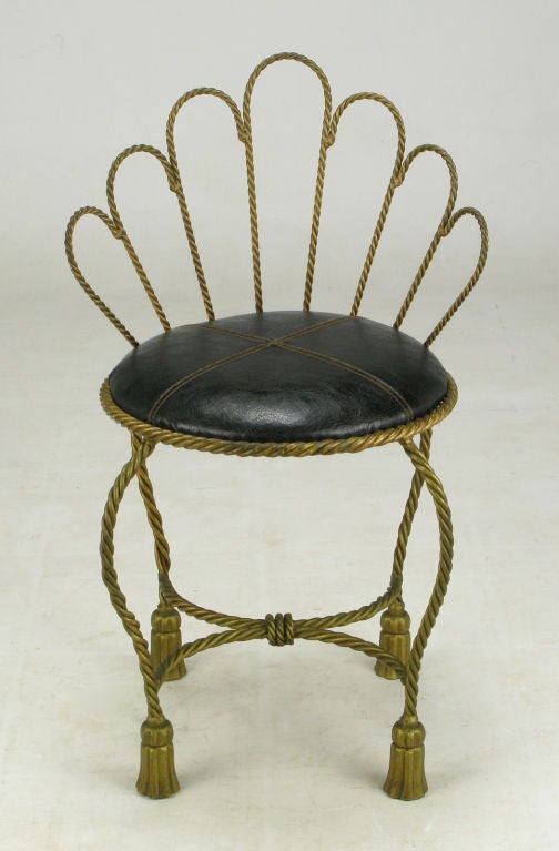 Patinated gilded brass rope design with brass tassel feet and open scalloped back. The seat is covered in a high quality double stitched pleather. The perfect petite regency vanity stool or bench.