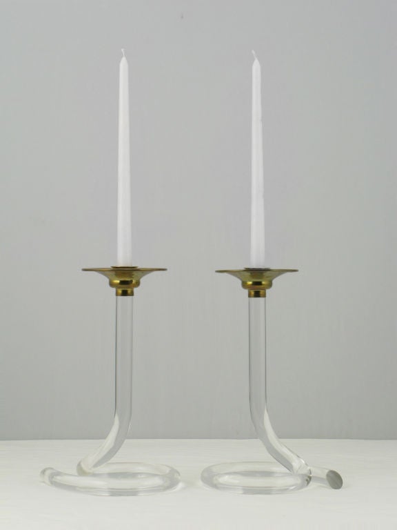 Exquisite pair of bent Lucite and brass candle sticks after Dorothy Thorpe. The Lucite bodies are evocatively coiled to resemble cobras.