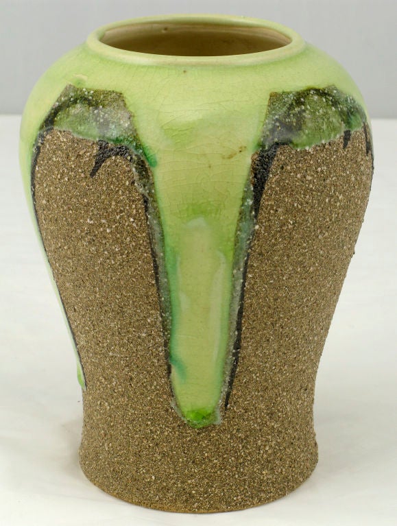 Unusual petite vase in a tradition Asian ginger jar form with the uncommon rough sand like finish. The celery colored glaze abstract forms are outlined in black.