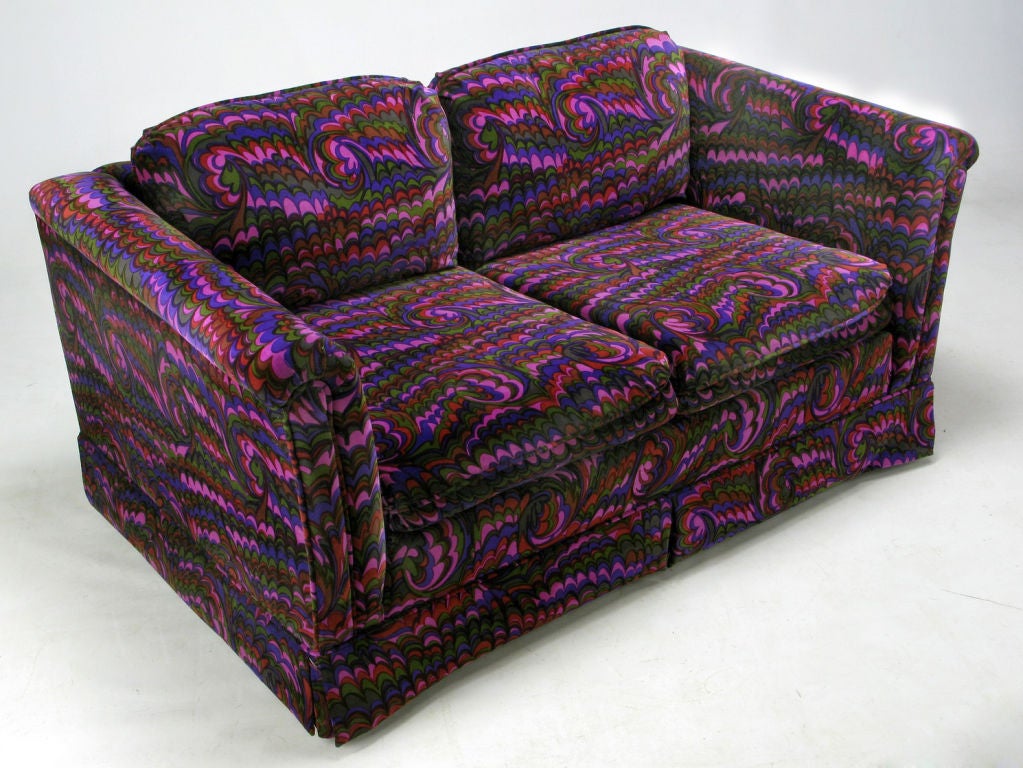 Beautiful original Jack Lenor Larsen upholstered rolled arm settee from the 1960s. An uncommon velvet pattern in violet, pink, blue, black and green, over a traditional form settee. Seat and back cushions are loose.