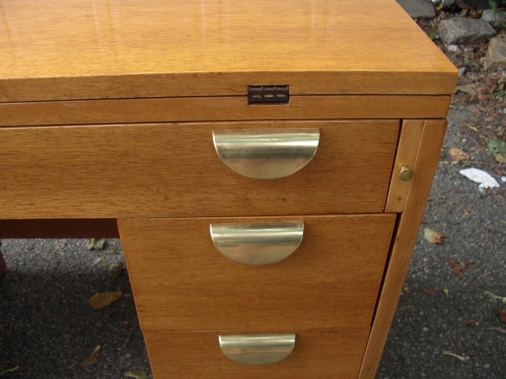 A neat 1950's light mahogany and brass extendable knee-hole desk with a 3-leaf folding adjustable top with extends up to 67 3/4 