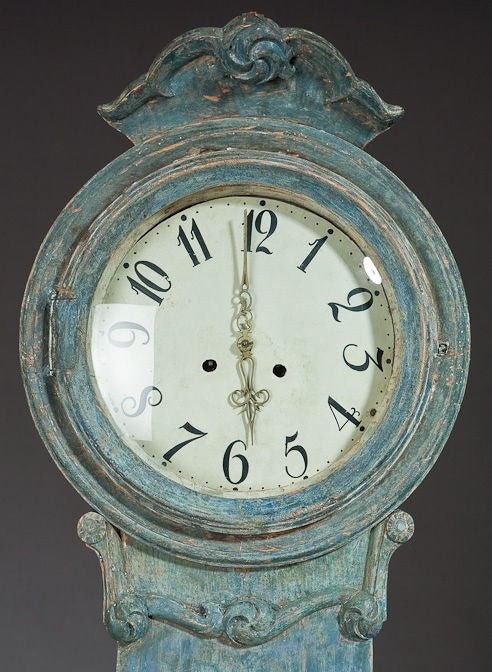 A  Gustavian Period, Tall Case Mora Clock in original surface with elegant carved details on the crown piece.