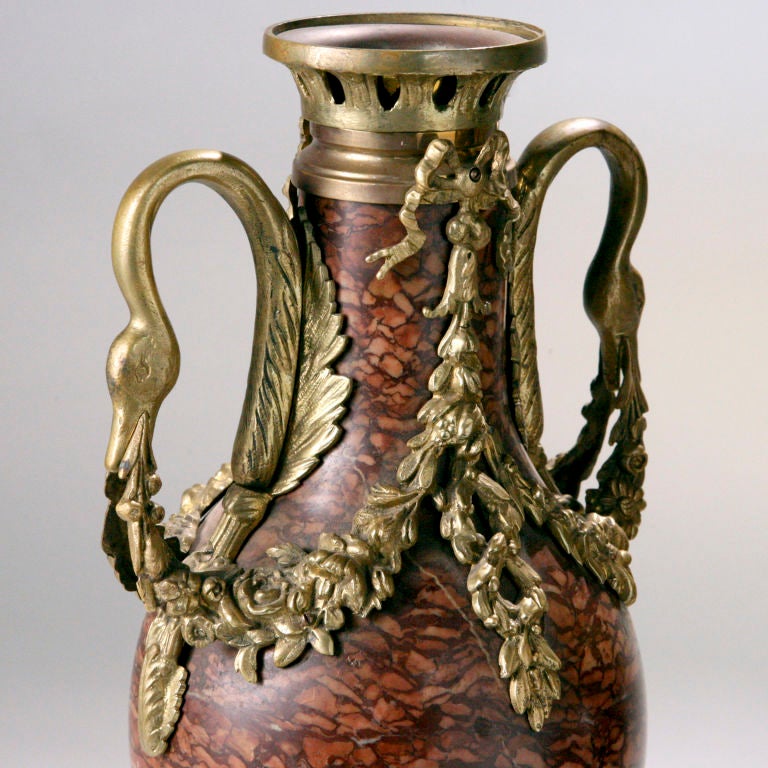 Importante coppia di vasi francesi in marmo reale decorati con ghirlande floreali in ormù e manici a collo di cigno. Raro colore rosa, circa 1810.