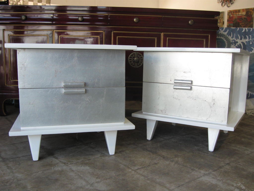 Elegant pair of Mid century, late 40's early 50's side tables, high gloss lacquered white with silver leaf front drawers.<br />
For addtional chairs, armchairs, dressers, commodes, vanities, sideboard, credenzas,bureaus, chests,