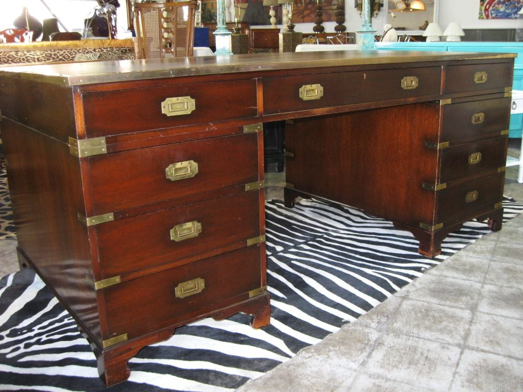 Superb traditional large English campaign desk, with brass frame, handles and brackets ALL AROUND. Leather top has vey nice patina and ware.<br />
This desk CAN FLOAT in a room, as the front has all faux bronze handles and mounts with an additional