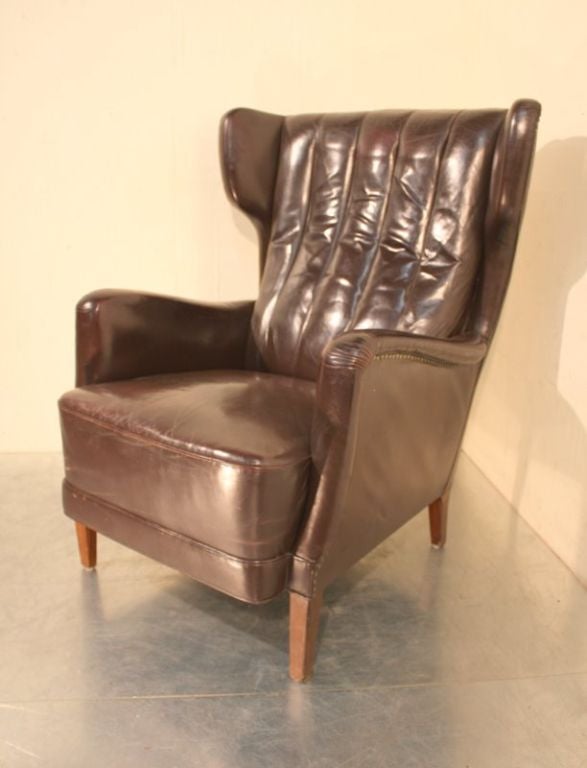 An original 1950’s leather Danish wing armchair. Cocoa brown, stunning design, large scale chair.