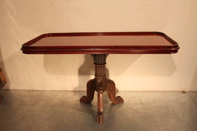 An original mahogany ship’s side table with cast iron base