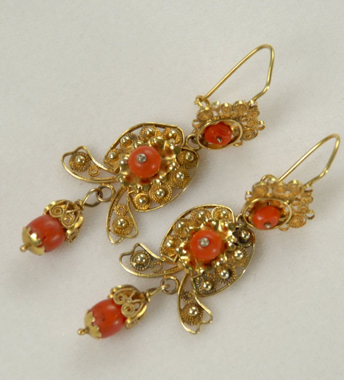 A pair of wonderful antique Mexican gold earrings with skillfully crafted gold wire, filigree and beautiful coral beads. Excellent wear and patina. Oaxaca - first quarter 20th century.<br />
<br />
Dimensions: hang 3 inches.